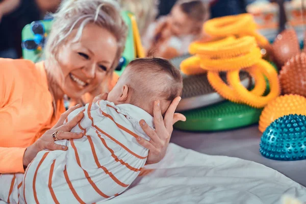 Glücklich lächelnde Frau bei der Massage für kleines Baby — Stockfoto