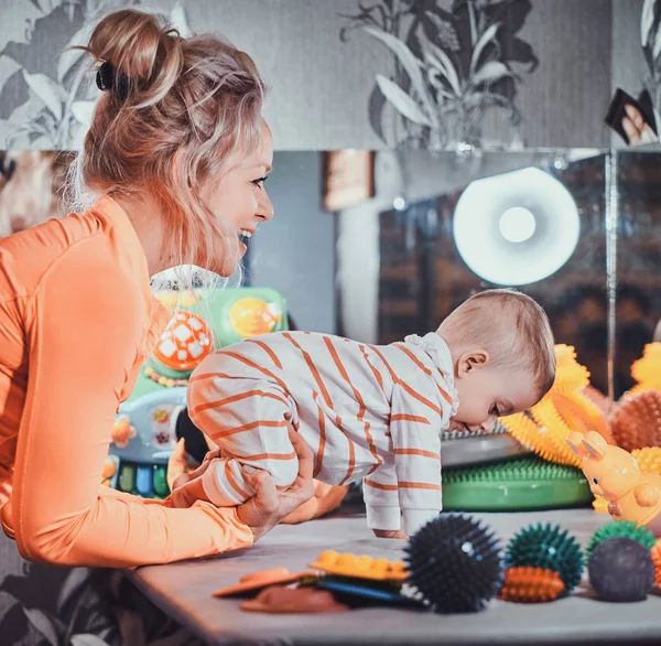 Szczęśliwy uśmiechnięta kobieta robi masaż dla małego dziecka — Zdjęcie stockowe