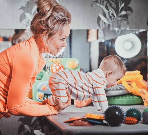 Gelukkig lachende vrouw doet massage voor kleine baby — Stockfoto