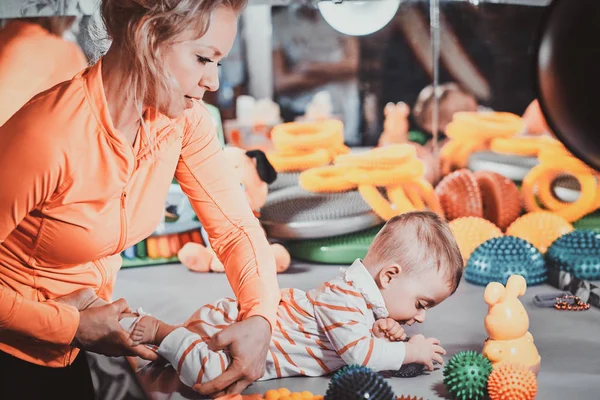 Fröhliche Mutter steht mit ihrem Neugeborenen im Masseur-Kabinett — Stockfoto