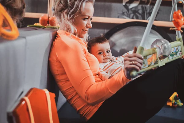 Fröhliche Mutter spielt mit ihrem Baby, während sie auf einen Arzt wartet — Stockfoto