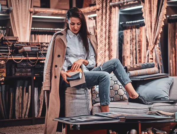 Diseñadora talentosa de moda está sentada en el sofá en su propio taller textil —  Fotos de Stock