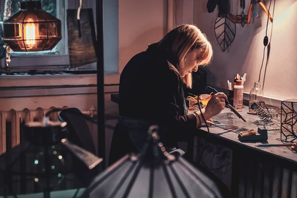 Mujer está trabajando en su proyecto de lámpara en el estudio de la lámpara . — Foto de Stock