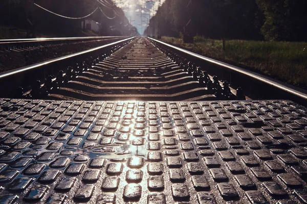 Photo en angle bas des rails et traverses et transition pédastrin — Photo