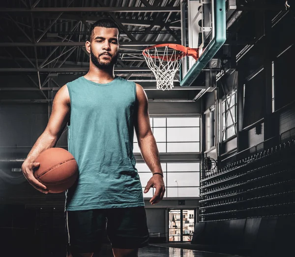 Jugador de baloncesto negro sostiene una pelota sobre un aro en un baloncesto — Foto de Stock