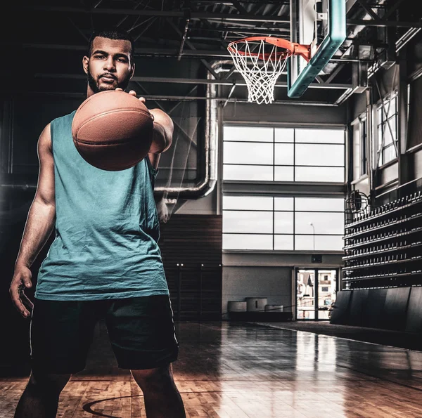 Jugador de baloncesto negro sostiene una pelota sobre un aro en un baloncesto — Foto de Stock