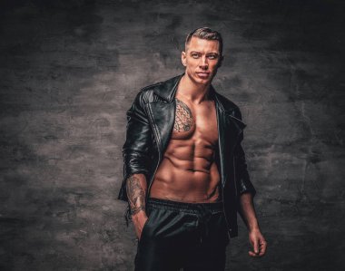 Çıplak gövdeüzerinde siyah deri ceket giymiş bir adam..