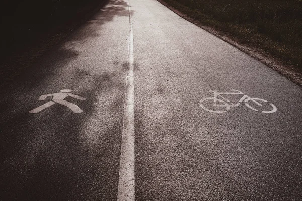 Asfaltová stezka, rozdělená na dvě části-jedna část pro cyklisty, jiná pro pedaušany. — Stock fotografie