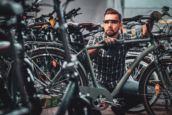 Занятой привлекательный мужчина в защитных очках очищает велосипед от грязи — стоковое фото