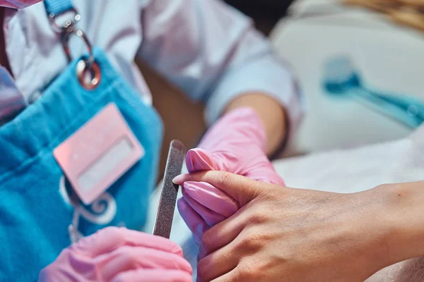 Una mujer está recibiendo cuidado de uñas de la manicura . —  Fotos de Stock