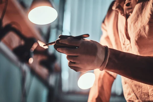 Meester in zijn restouration workshop met lagen en vrede van glas in zijn handen. — Stockfoto