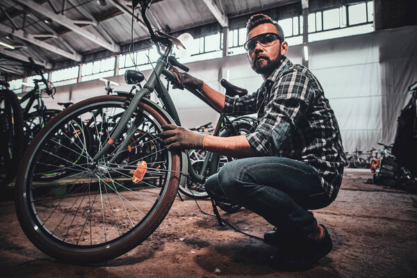 Attractive male is fixing tyres for busy customer.