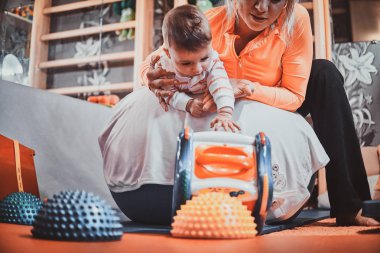 Expirienced pegiatrist sevimli küçük yürümeye başlayan çocuk için özel egzersizler yapıyor