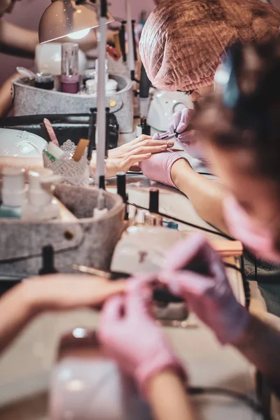 Estudio de manicura ocupado con un montón de personal de trabajo y clientes . —  Fotos de Stock