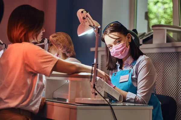 Junge attraktive Maniküre macht Nagelpflege für eine andere Frau — Stockfoto