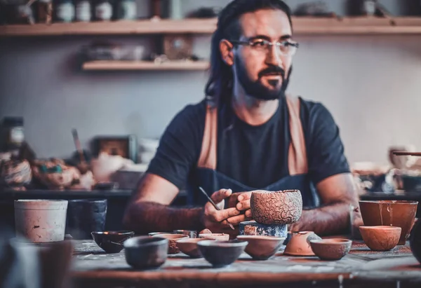 Talented artist at his own pottery studio is workig for new project.