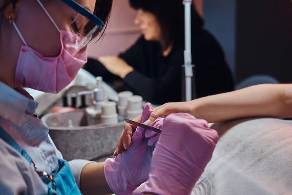 Manicurista di talento sta lavorando sulle unghie dei clienti — Foto Stock