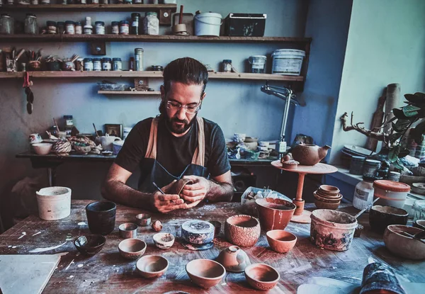 Ентузіастичний гончар в окулярах на своїй майстерні це робота над новим чайником ручної роботи . — стокове фото