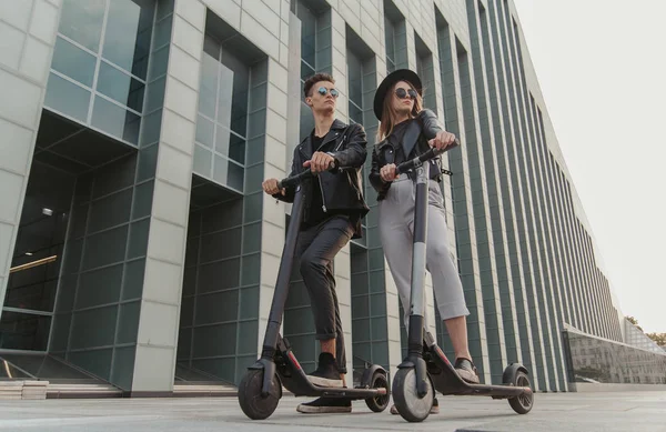 Pareja romántica casual en scooters están montando en la ciudad —  Fotos de Stock