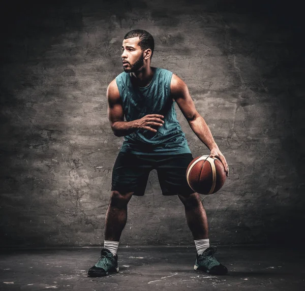 En svart Basketspelare leker med en boll. — Stockfoto