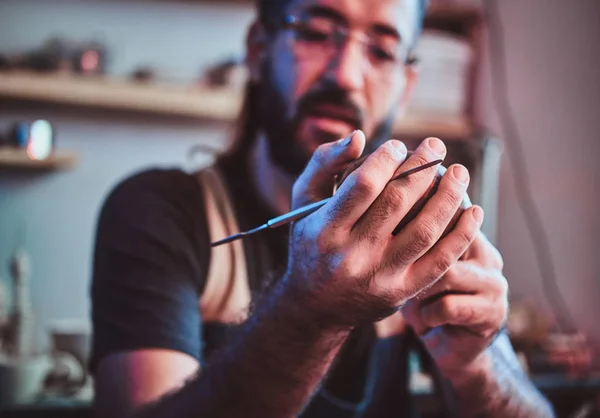 Diligent cher homme dans des lunettes à son atelier de poterie est de travail pour un nouveau projet . — Photo