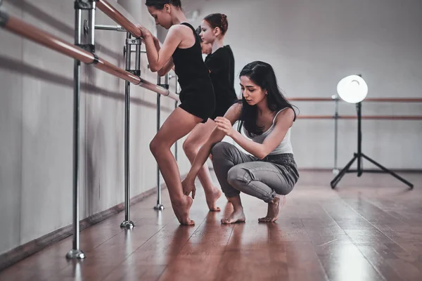 Expirienced nauczyciel baletu pokazuje do młodych dziewcząt, jak zrobić ważne ćwiczenia — Zdjęcie stockowe