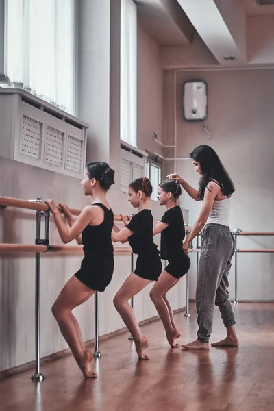 Professeur de ballet expiré montre aux jeunes filles comment faire des exercices importants — Photo