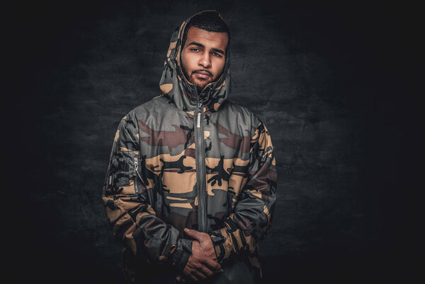 Black male dressed in a camouflage jacket.