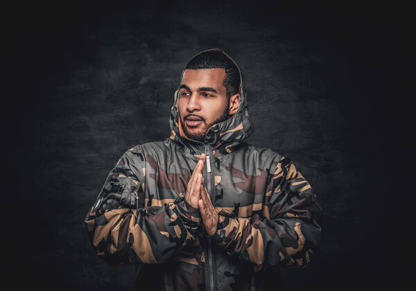 Black male dressed in a camouflage jacket.