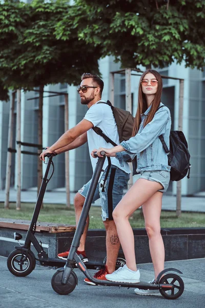 Młoda para cieszy się jazdą na skuterach elektrycznych — Zdjęcie stockowe