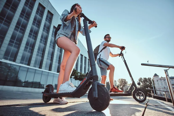 Deux amis profitent de la journée d'été avec leurs scooters électriques — Photo