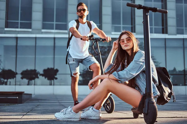 Casal de dois bons amigos estão arrepiando com suas scooters — Fotografia de Stock