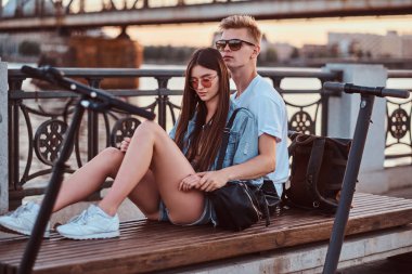 Scooter'ları ile gün batımının tadını çıkaran çekici çift