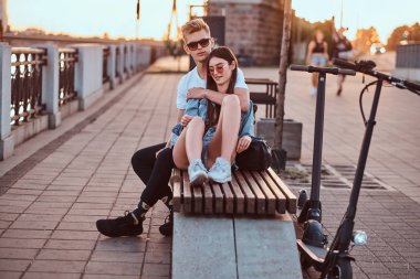 Scooter'ları ile gün batımının tadını çıkaran çekici çift