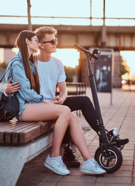 Scooter'ları ile gün batımının tadını çıkaran çekici çift