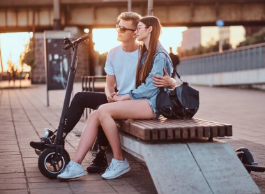 Scooter'ları ile gün batımının tadını çıkaran çekici çift