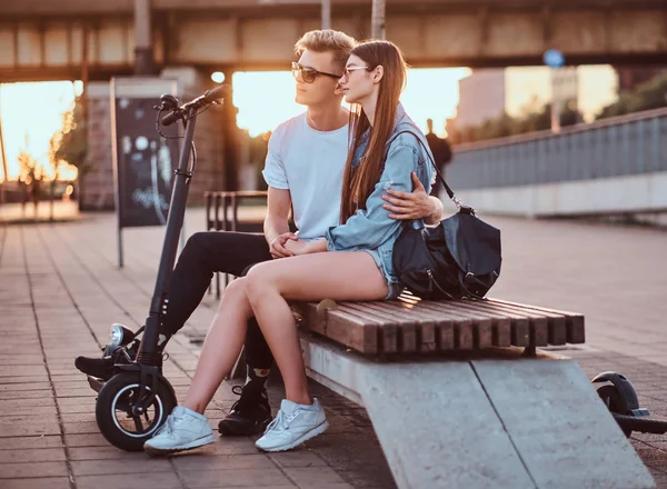 Приваблива пара насолоджується заходом сонця зі своїми скутерами — стокове фото