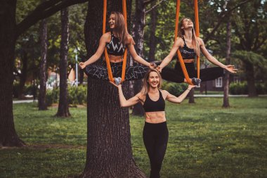 Eğitmen ve iki öğrencisi yaz parkında fotoğrafçıiçin poz lar verler.