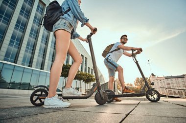 İki arkadaş elektro scooter ile yaz günü tadını çıkarıyor