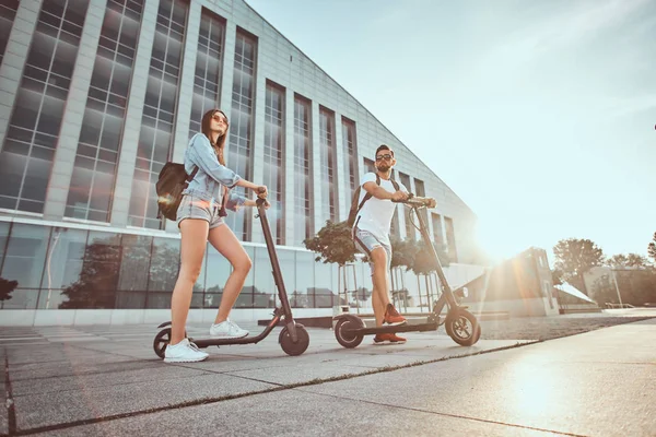 Deux amis profitent de la journée d'été avec leurs scooters électriques — Photo