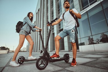 İki arkadaş elektro scooter ile yaz günü tadını çıkarıyor