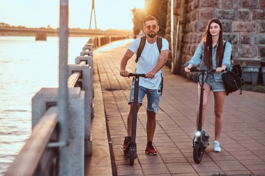 İki arkadaş elektro scooter ile yaz günü tadını çıkarıyor