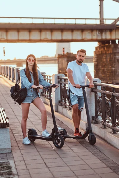 Jong stel is genieten van electro scooters rijden — Stockfoto