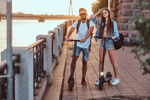 Due amici si stanno godendo la giornata estiva con i loro scooter elettrici — Foto Stock