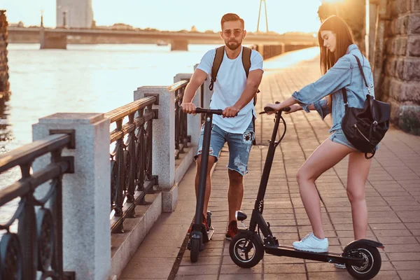 Jong stel is genieten van electro scooters rijden — Stockfoto