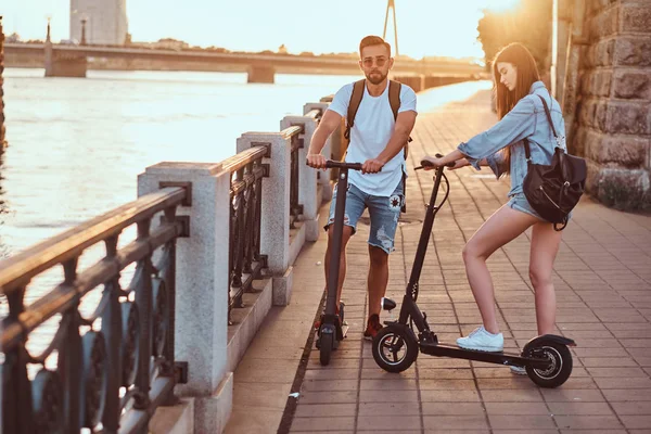 Jovem casal está desfrutando de scooters electro equitação — Fotografia de Stock