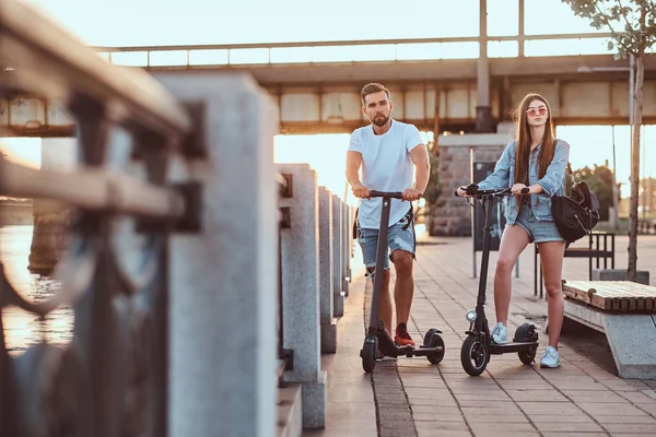 Jong stel is genieten van electro scooters rijden — Stockfoto