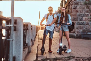 İki arkadaş elektro scooter ile yaz günü tadını çıkarıyor