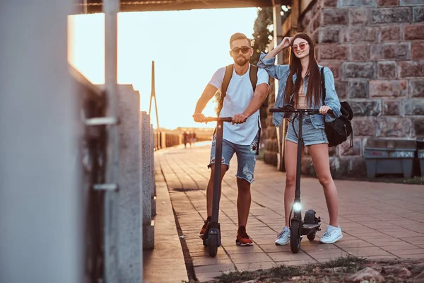 Dois amigos estão desfrutando do dia de verão com seus scooters eletro — Fotografia de Stock