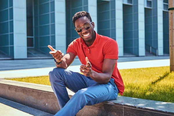 Przystojny Afro student siedzi w pobliżu jego praca — Zdjęcie stockowe